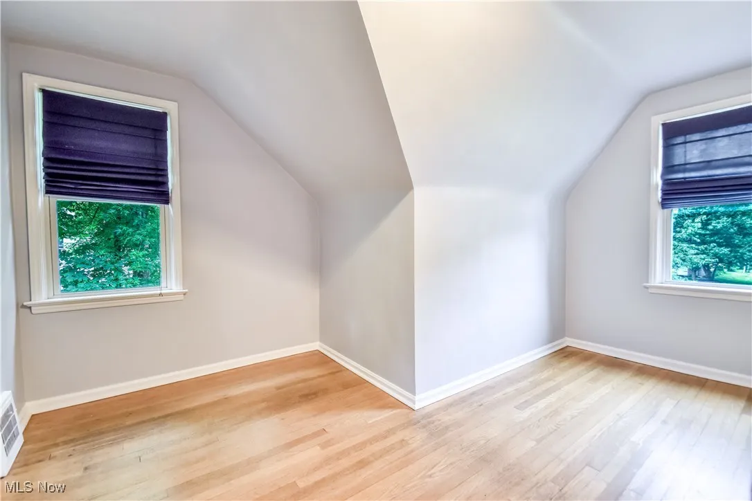 Additional living space featuring vaulted ceiling and wood finished floors