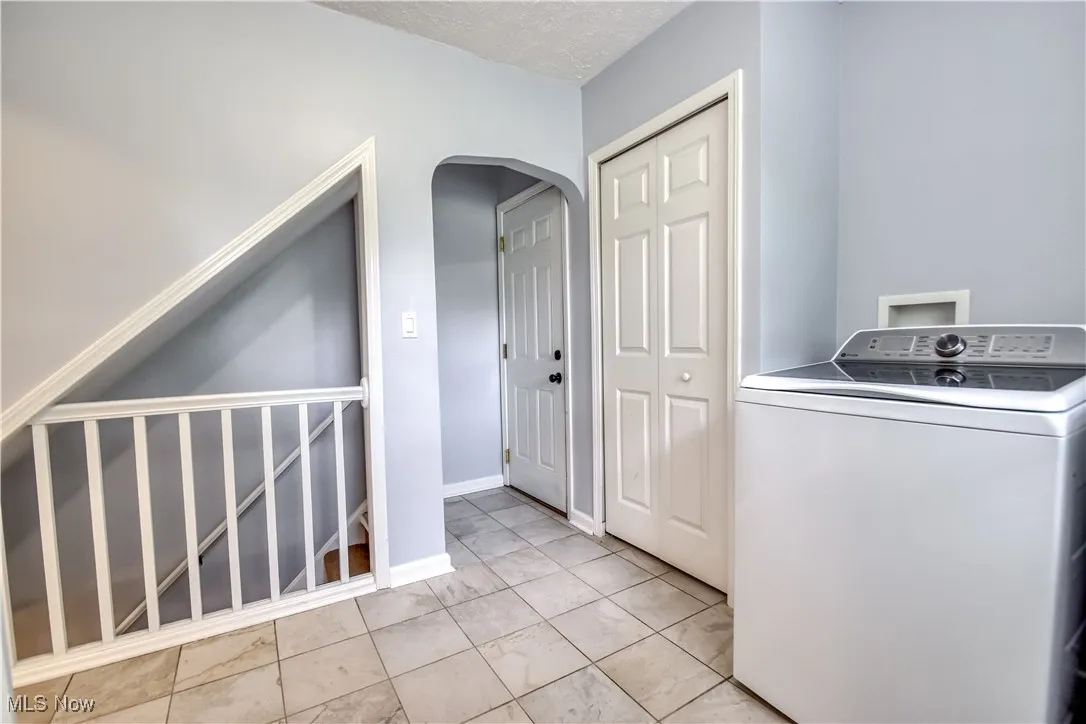 Laundry area featuring washer / clothes dryer and arched walkways