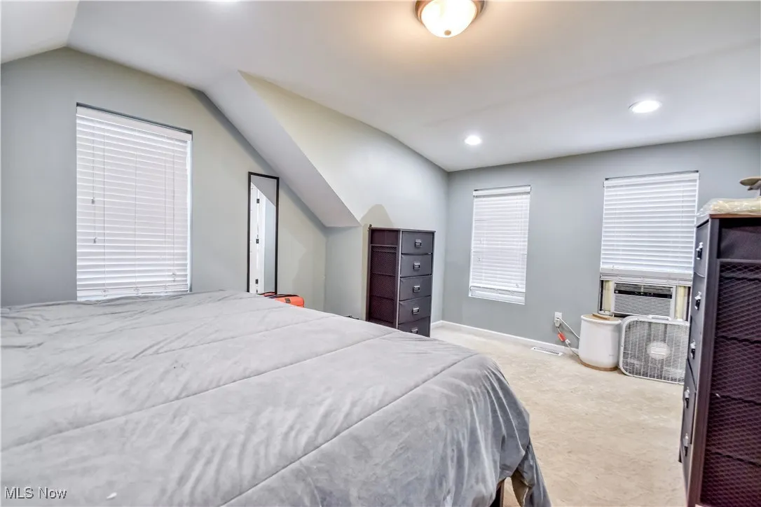 Carpeted bedroom featuring lofted ceiling and recessed lighting