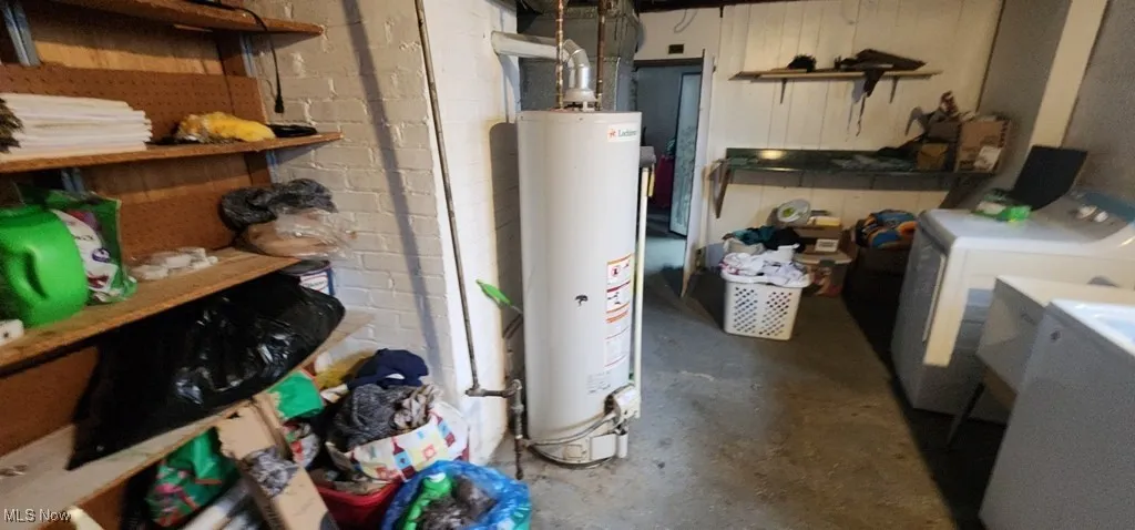 Unfinished basement with water heater and washing machine and clothes dryer
