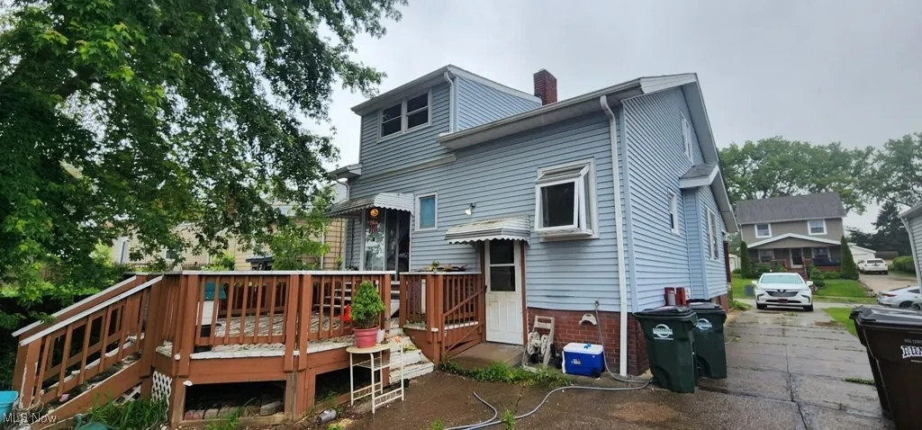 Back of house with a chimney and a wooden deck