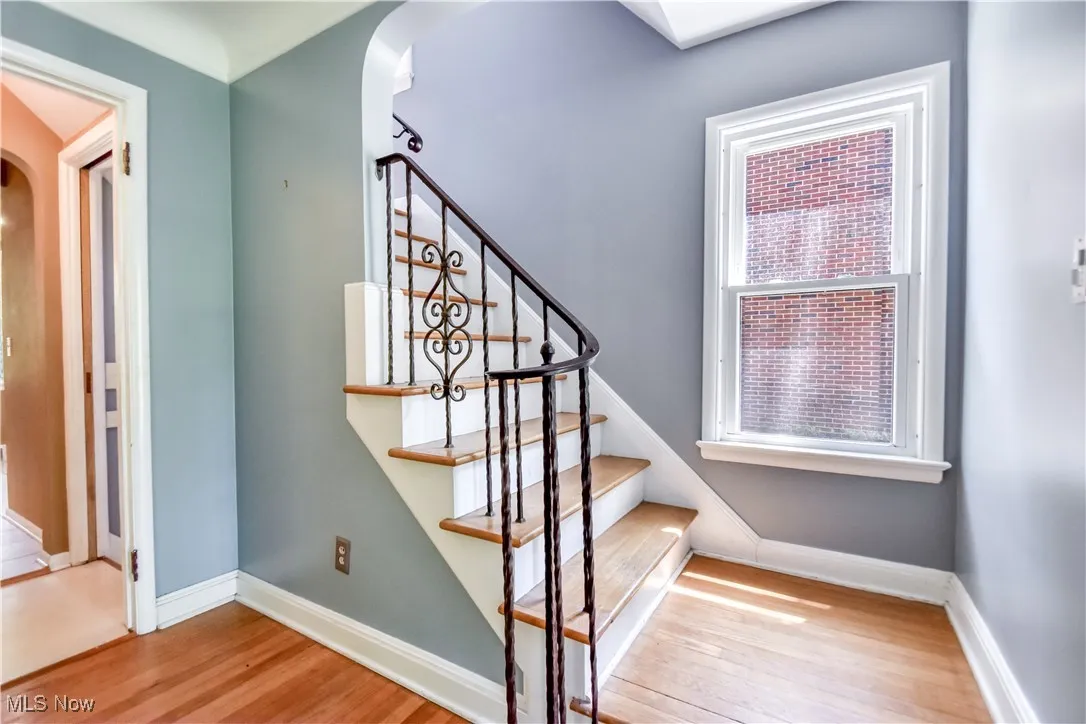 Stairway with arched walkways and wood finished floors