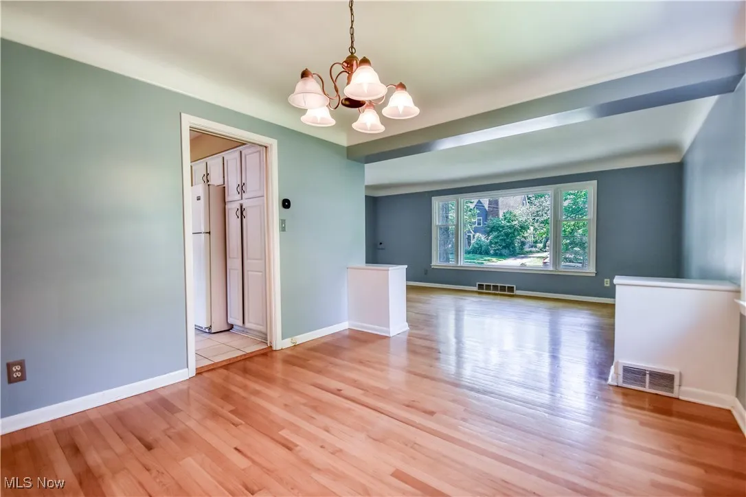 Spare room featuring a chandelier and light wood-style floors