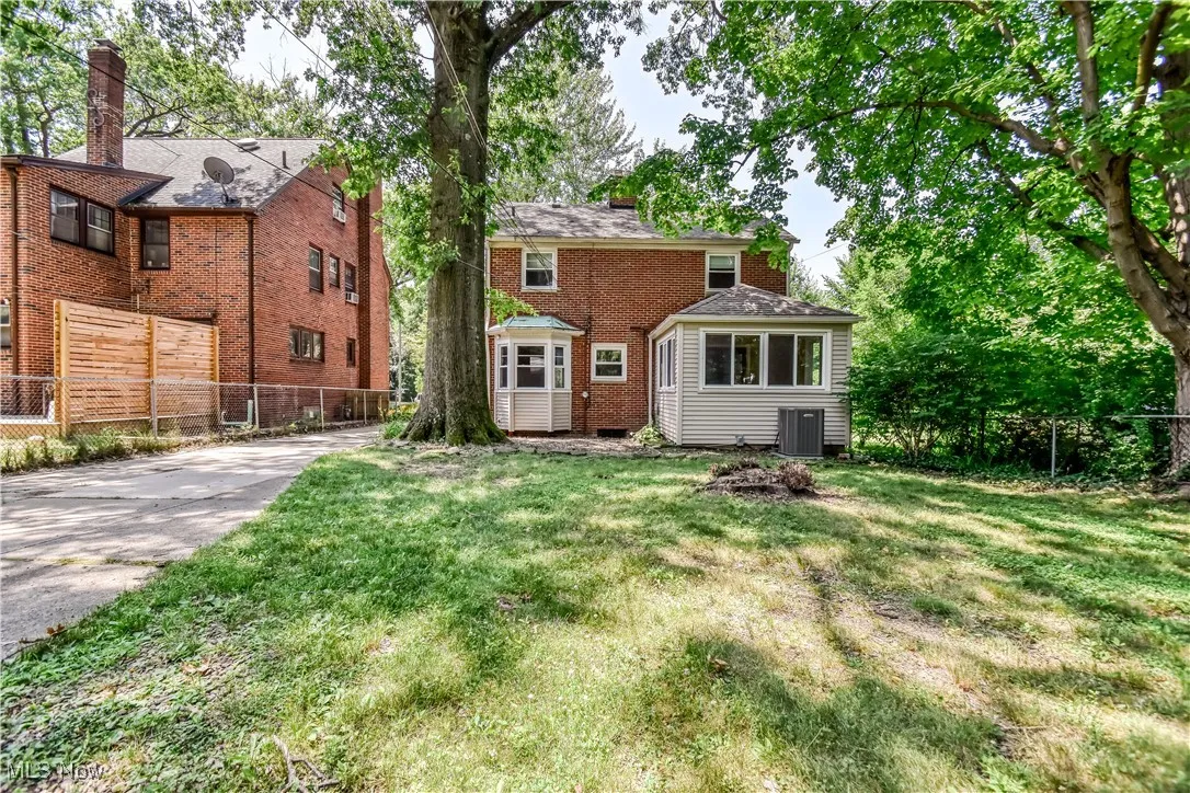 View of front of house featuring brick siding and a chimney