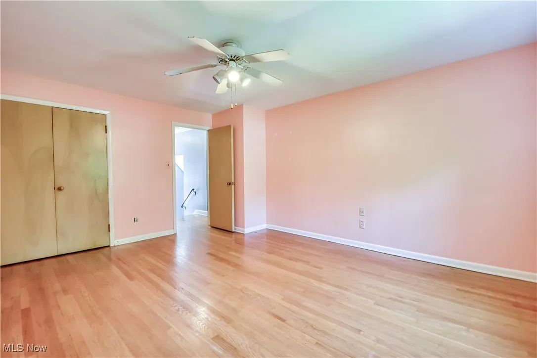 Unfurnished bedroom featuring light wood finished floors, ceiling fan, and a closet