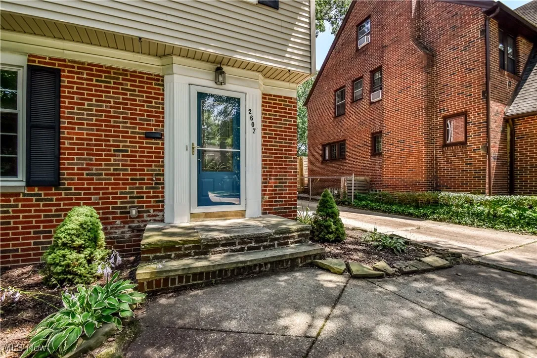 Doorway to property featuring brick siding