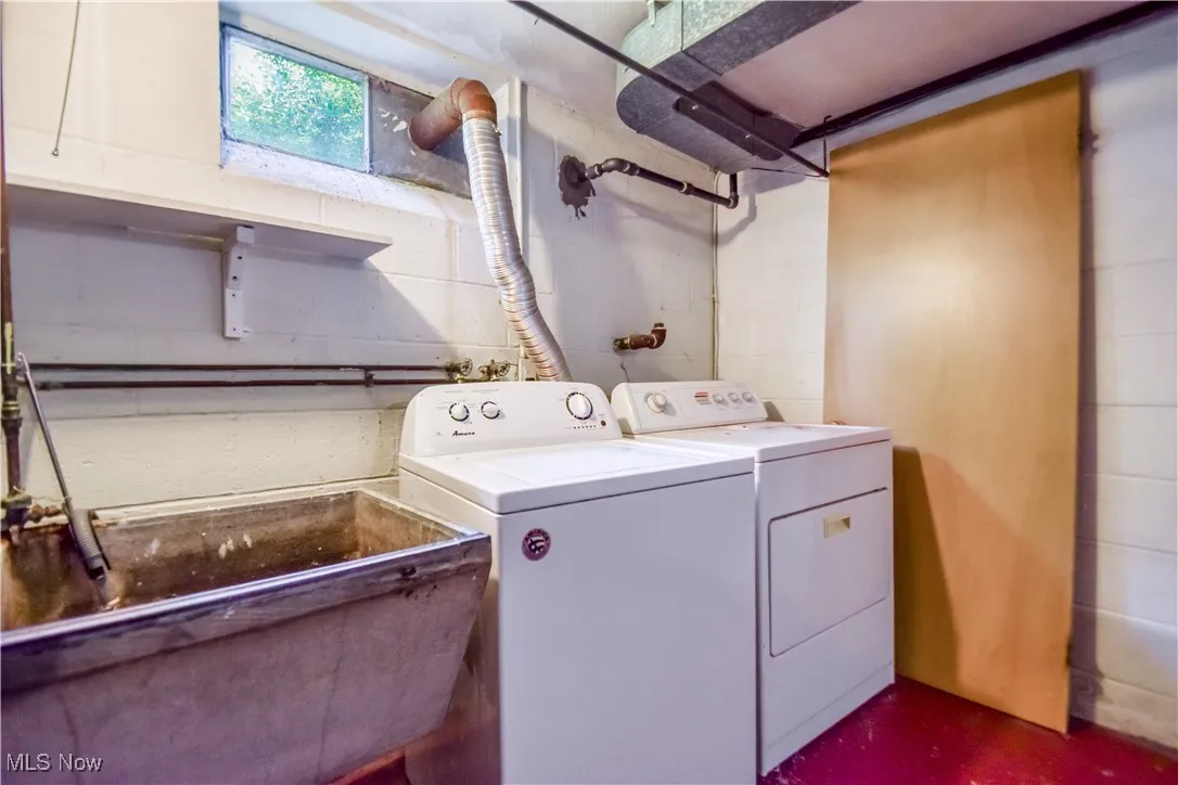 Laundry room with washer and dryer and concrete block wall
