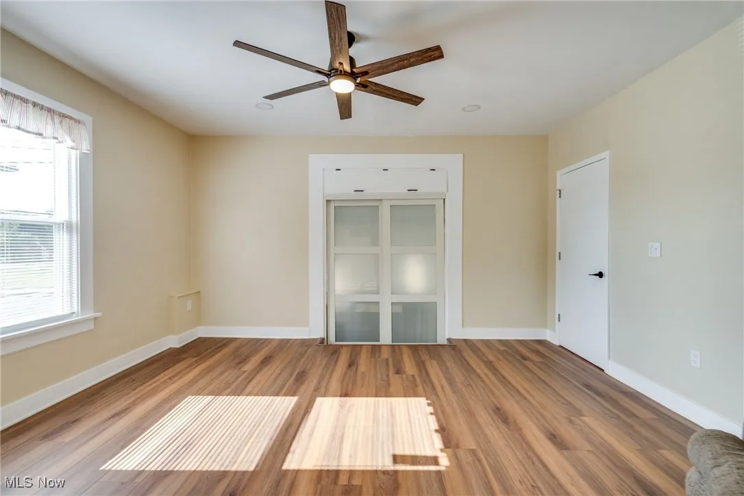 Unfurnished room featuring ceiling fan, plenty of natural light, and wood finished floors