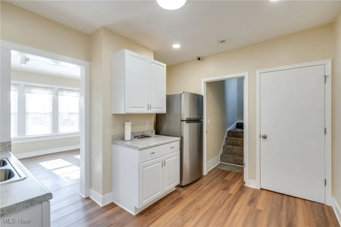 Kitchen featuring freestanding refrigerator, light wood-style floors, white cabinetry, light countertops, and recessed lighting