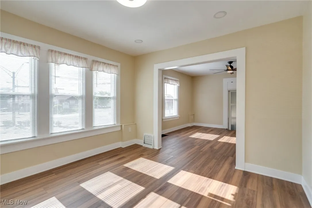 Empty room with wood finished floors and a ceiling fan