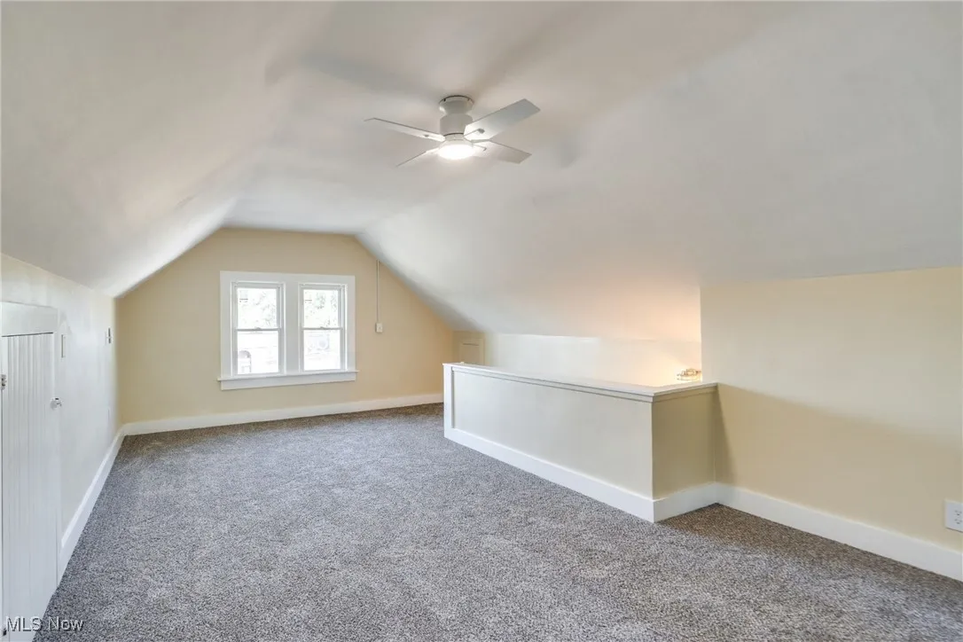 Bonus room featuring carpet floors, lofted ceiling, and a ceiling fan