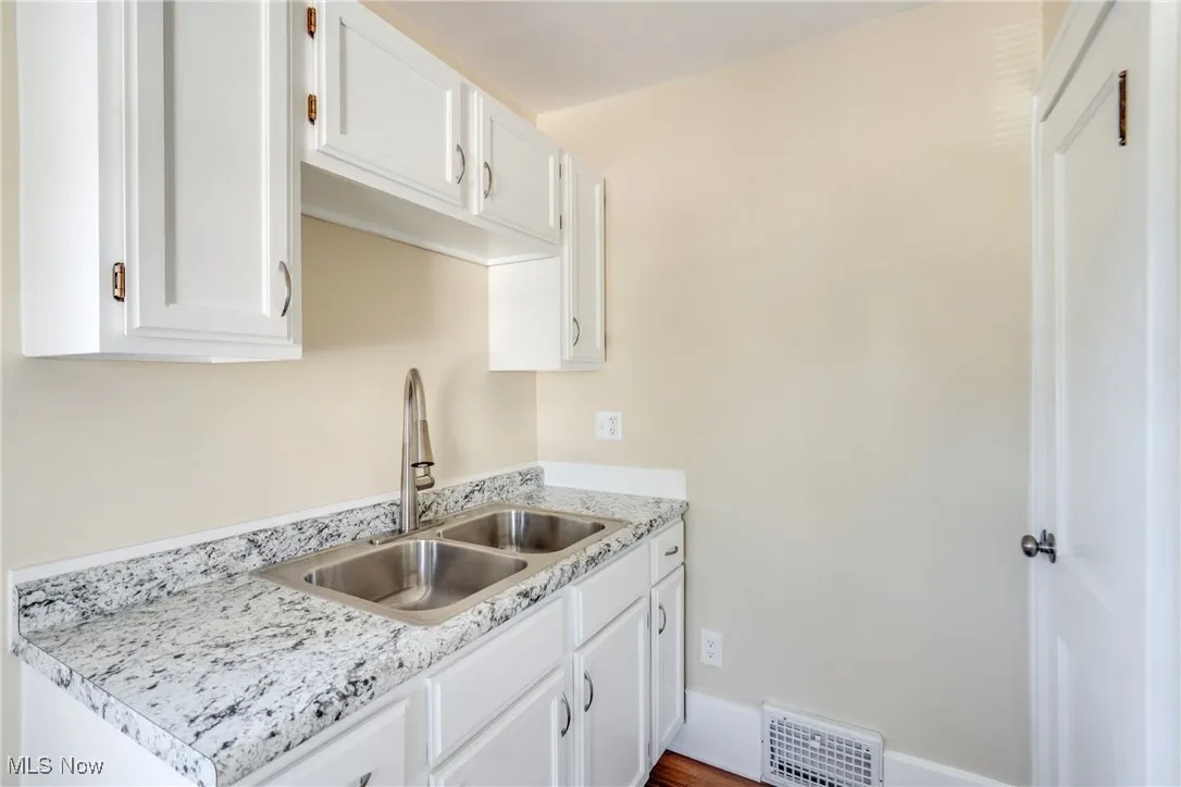 Kitchen featuring a sink and white cabinets