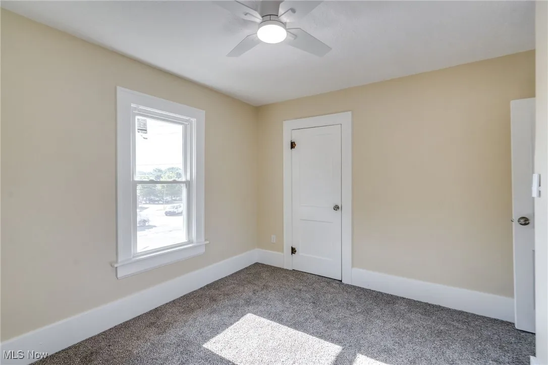 Spare room featuring carpet and ceiling fan