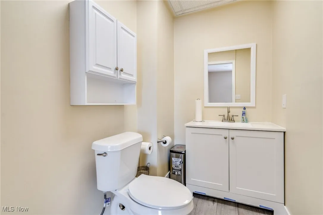 Half bath with vanity and wood finished floors