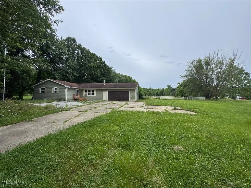 Ranch-style house with concrete driveway and an attached garage