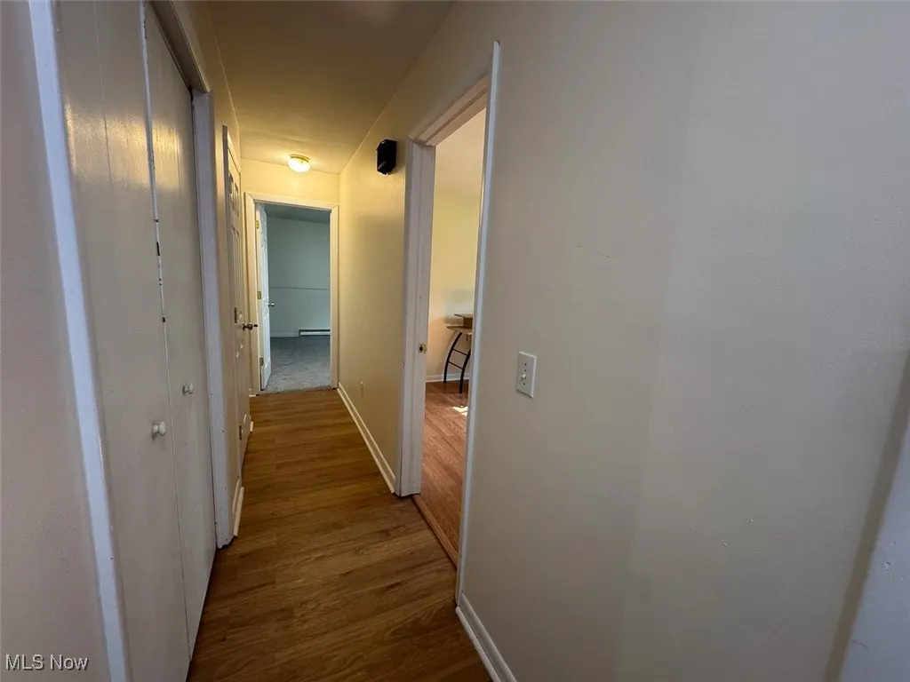 Hallway with wood finished floors and baseboards
