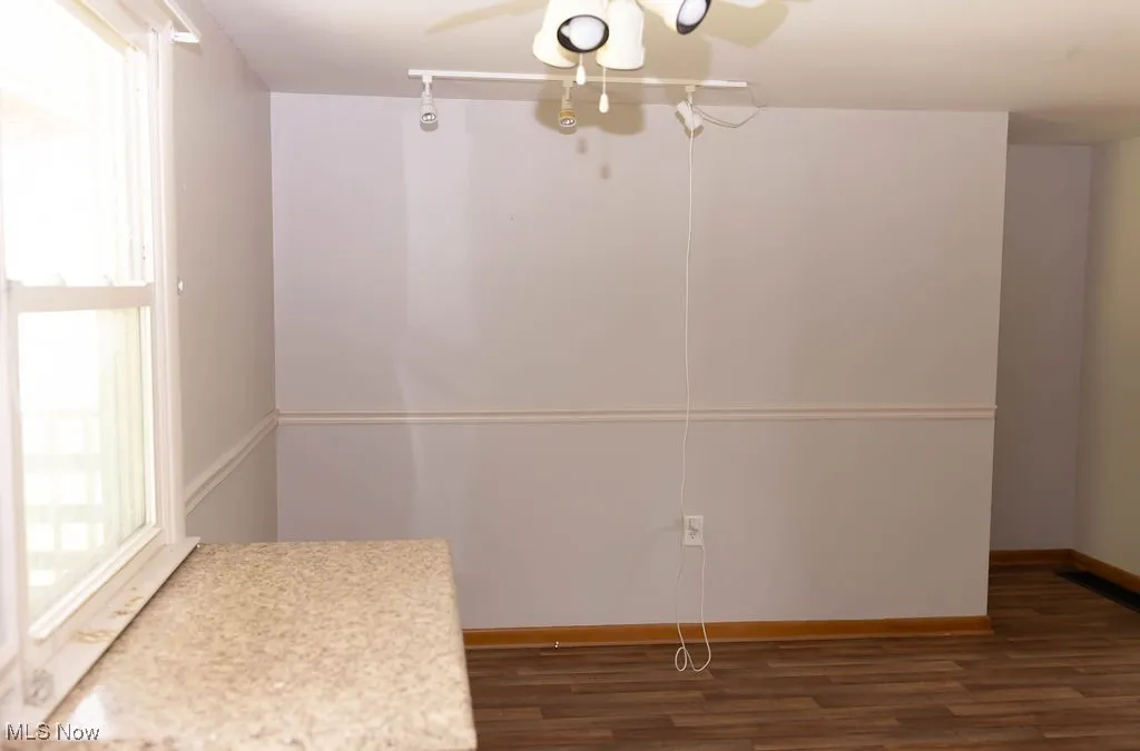 Unfurnished dining area with wood finished floors and a ceiling fan