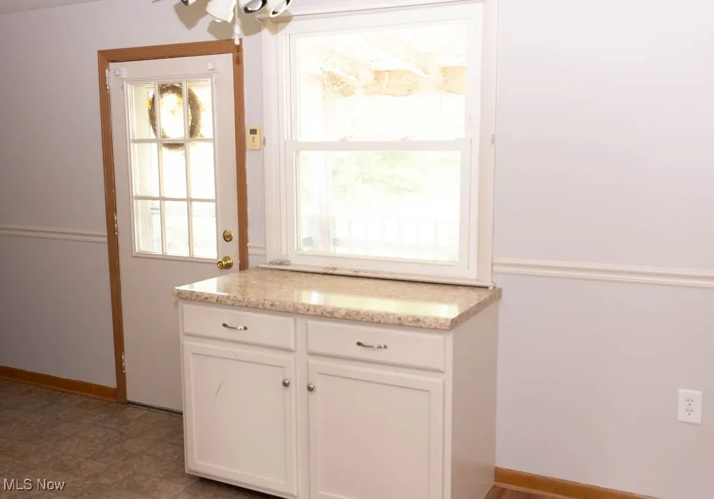 Kitchen with white cabinets and light stone countertops