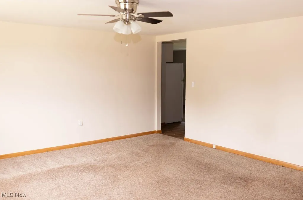 Unfurnished room featuring carpet floors and a ceiling fan