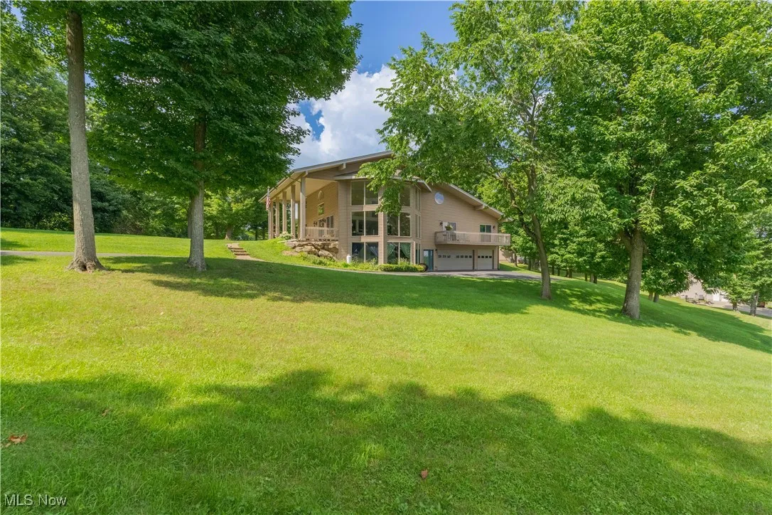 View of green lawn featuring an attached garage