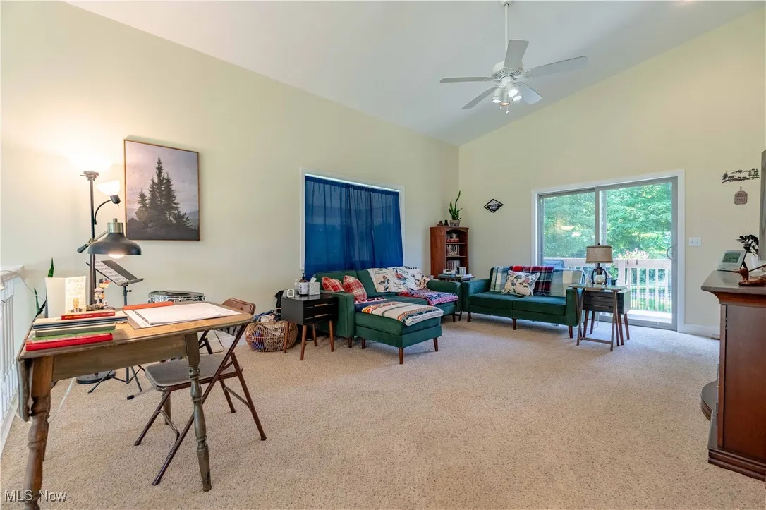 Office area with carpet flooring, high vaulted ceiling, and ceiling fan