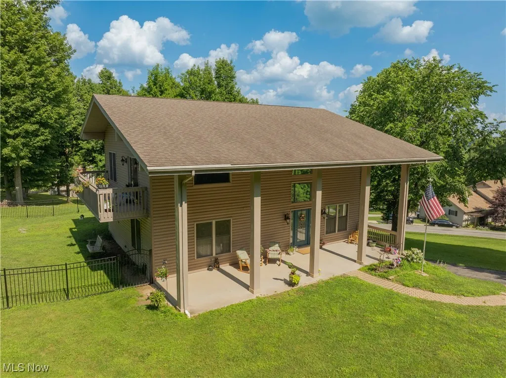 Rear view of house with a patio area and roof with shingles