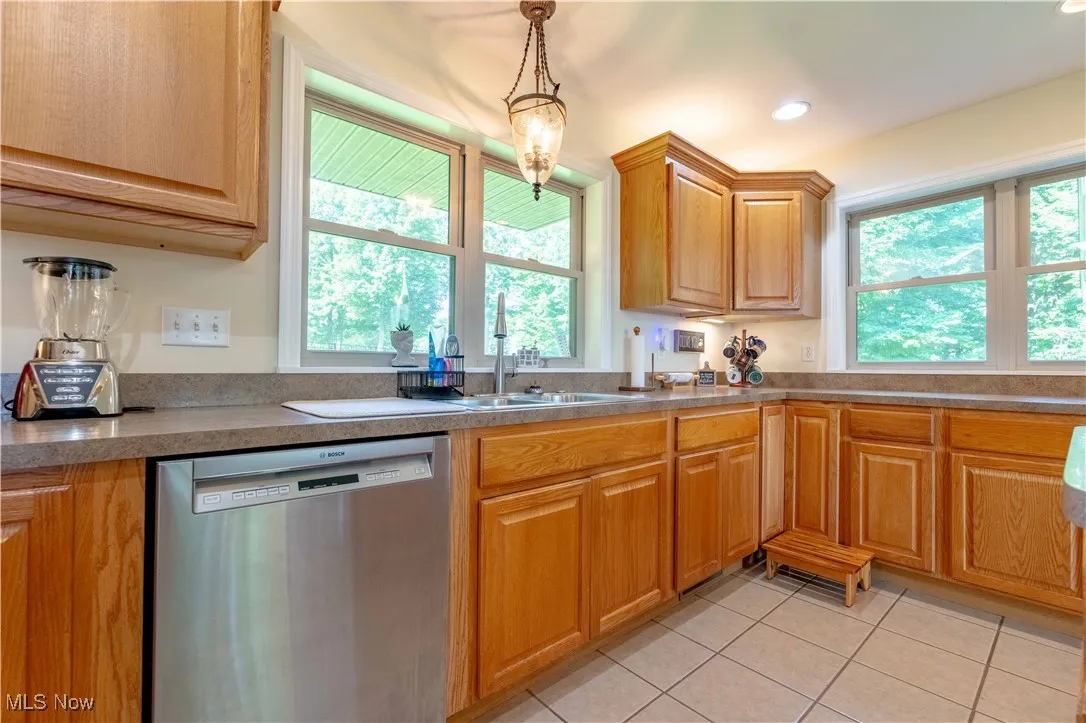 Kitchen with dishwasher, light tile patterned floors, pendant lighting, and recessed lighting