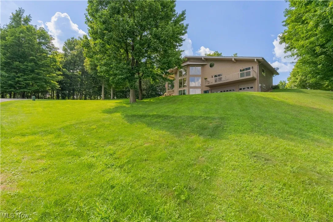 View of green lawn with a garage
