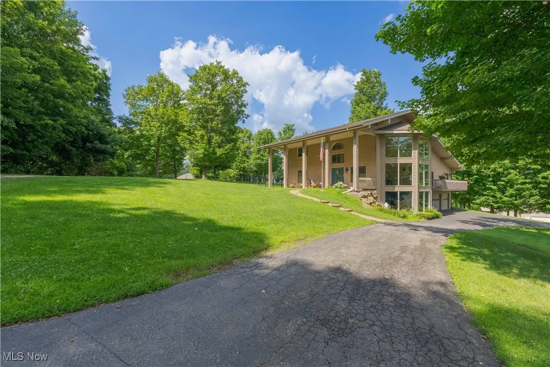 View of green lawn featuring asphalt driveway