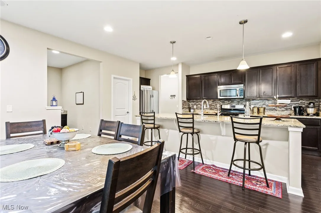 Dining space featuring dark wood finished floors and recessed lighting