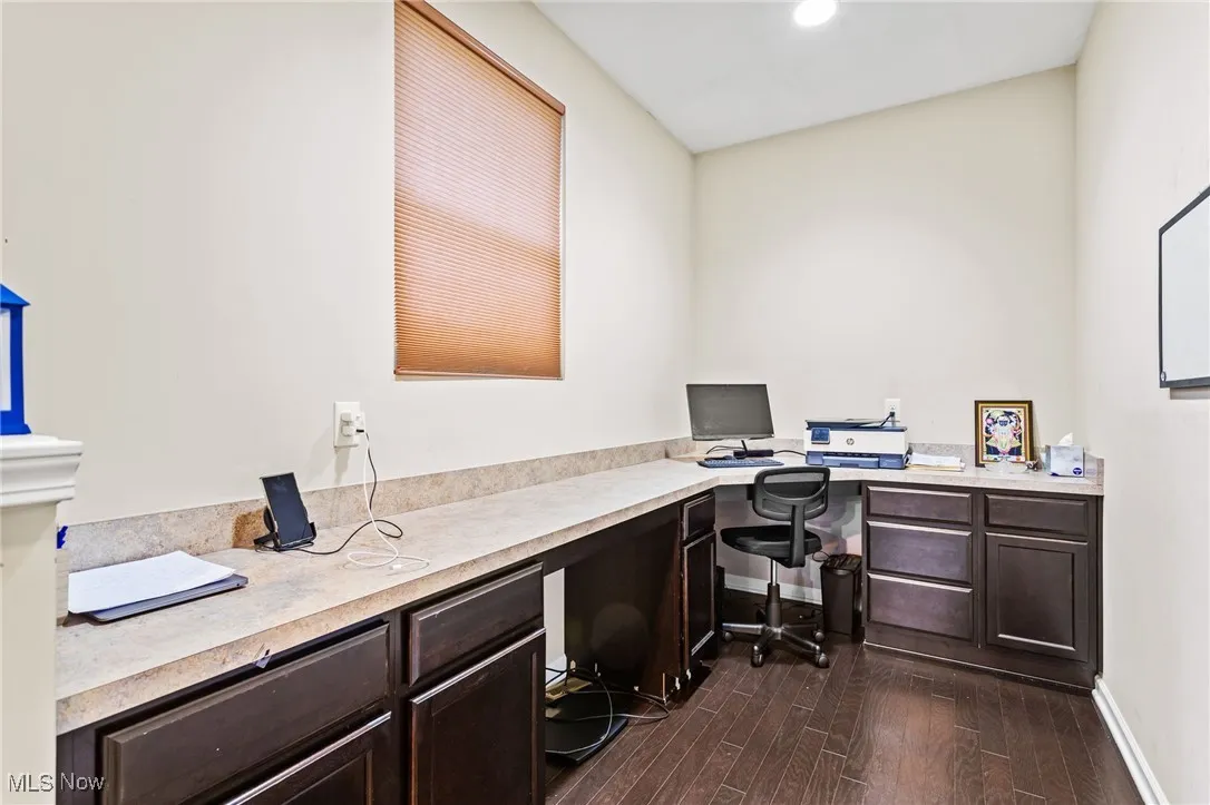 Office with built in desk, dark wood-style flooring, and recessed lighting
