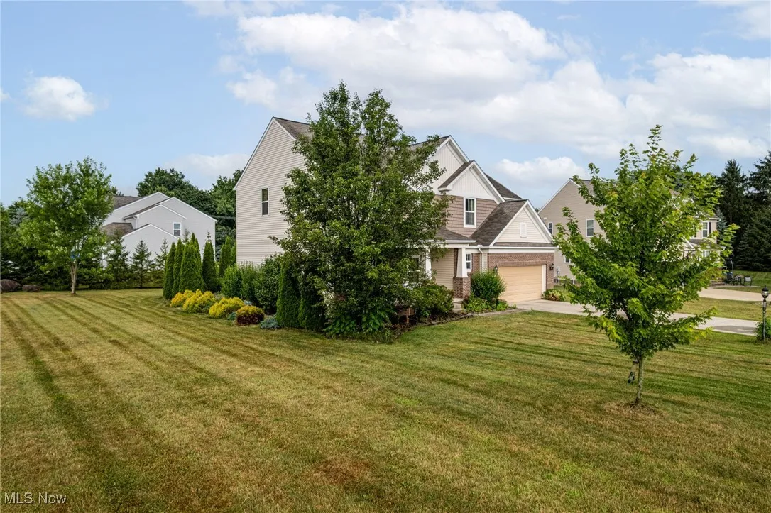 View of front facade featuring driveway, a front lawn, and an attached garage