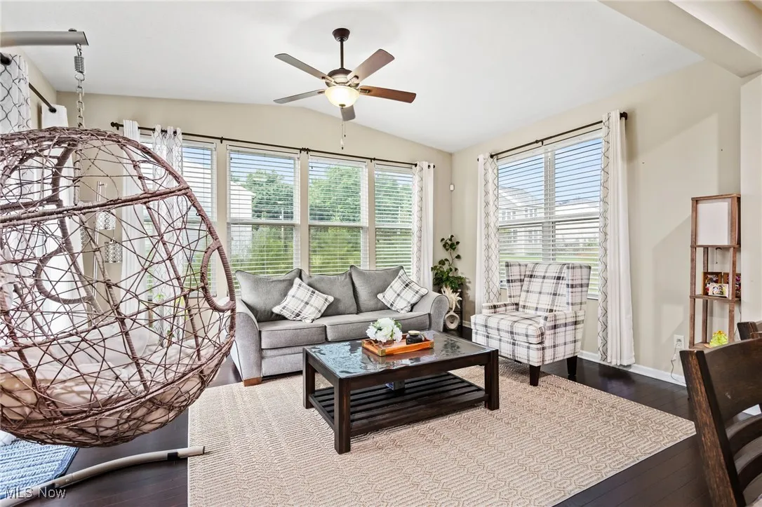 Living area featuring ceiling fan, lofted ceiling, and wood finished floors