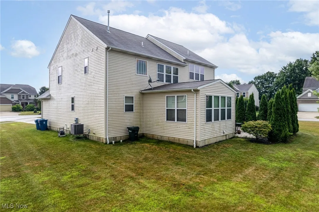 Back of property with a lawn