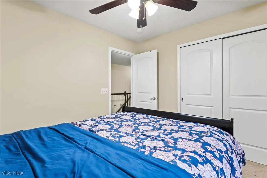 Bedroom featuring ceiling fan, a closet, and carpet flooring