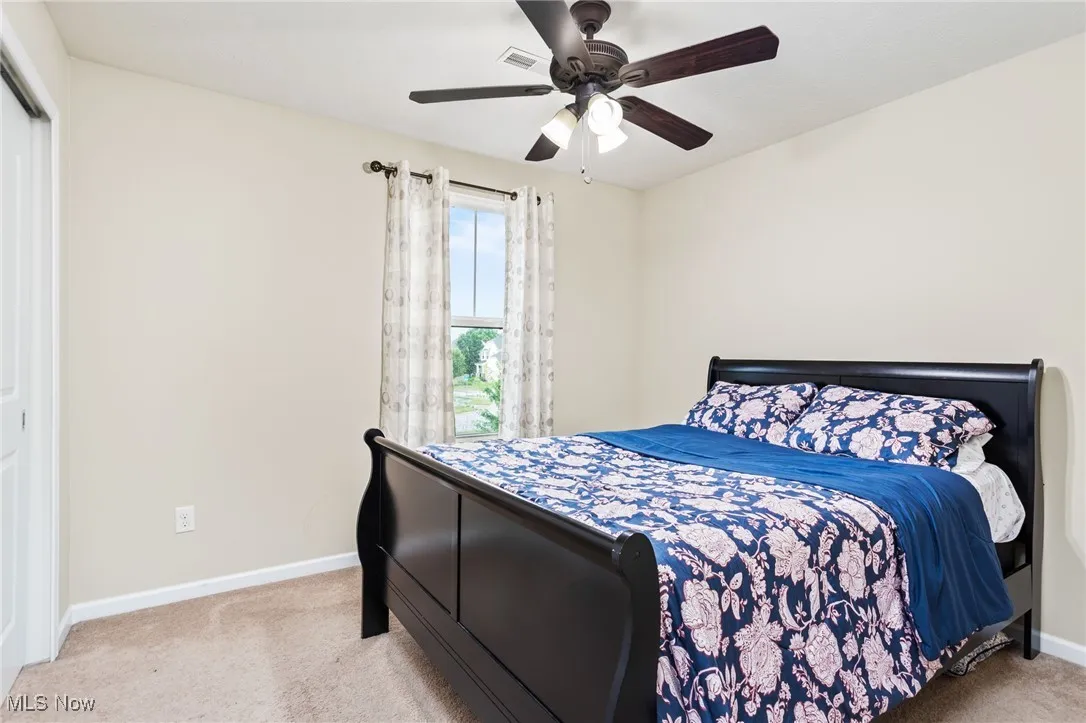 Bedroom with carpet, a ceiling fan, and a closet