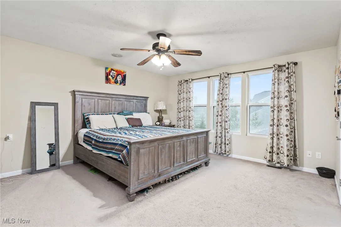 Bedroom with light carpet and ceiling fan