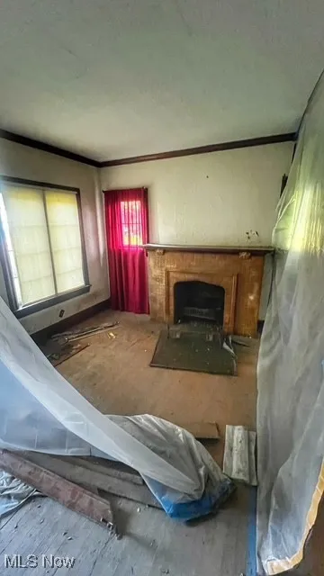 Living room with a fireplace with flush hearth and ornamental molding