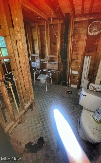 Miscellaneous room with tile patterned floors and wooden walls