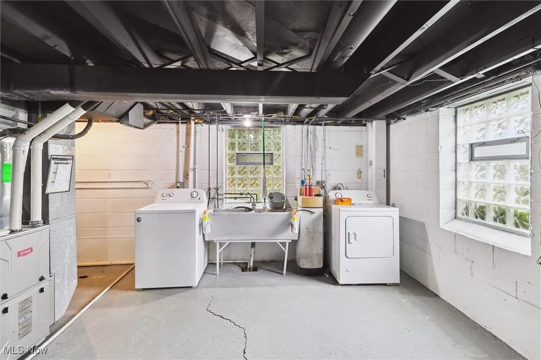 Basement featuring washer and clothes dryer, heating unit, and plenty of natural light