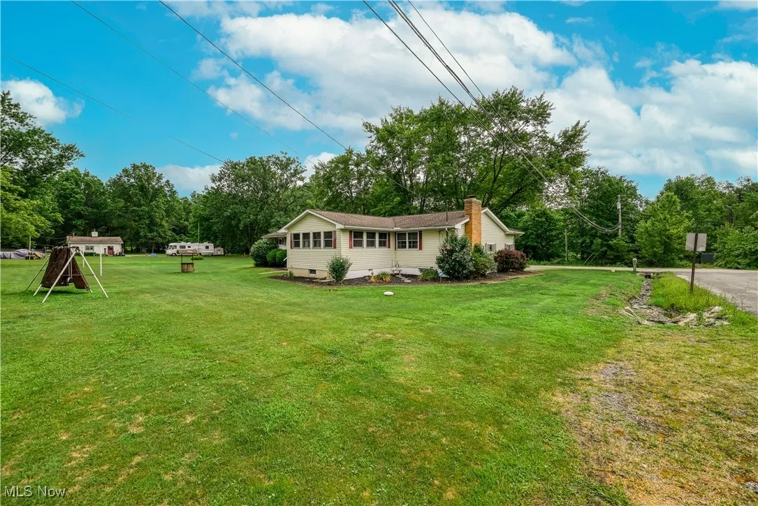 View of green lawn with view of wooded area