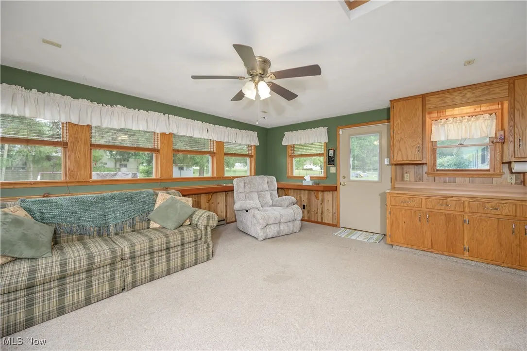 Living room featuring light carpet and a ceiling fan