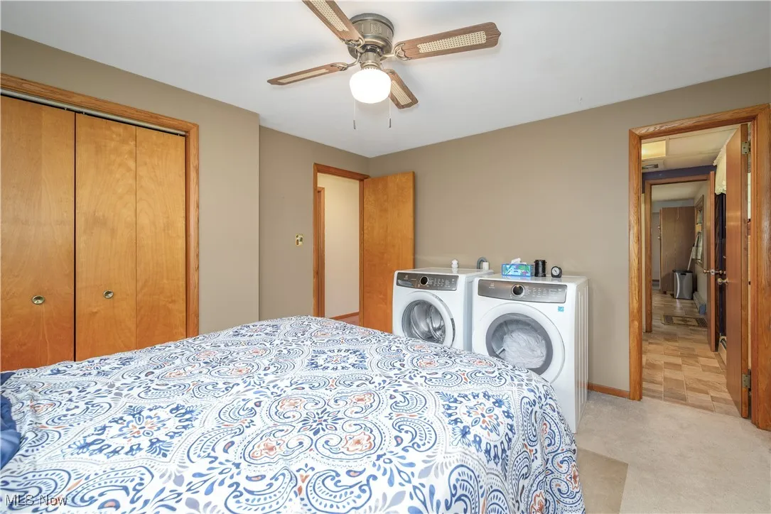 Bedroom featuring washer and dryer, a closet, and a ceiling fan
