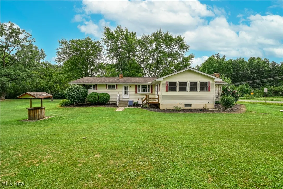 Rear view of property with a chimney and a yard