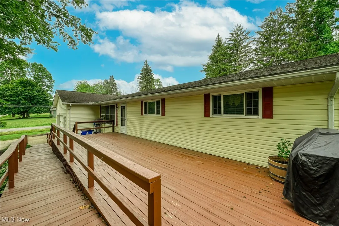 Wooden deck featuring a grill