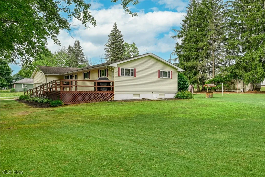Back of house featuring a yard and a deck