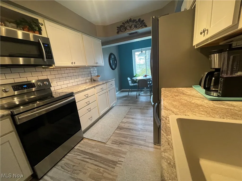 Updated kitchen, with luxury vinyl floors, large sink and fully stainless steel applianced and tiled .  Eat-in area a delight for your morning coffee, a soduko game or any meal!