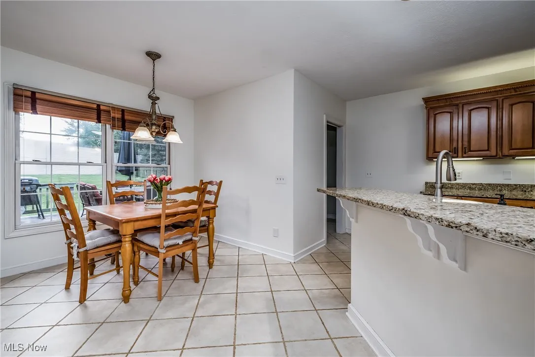 Dining space with baseboards and light tile patterned floors