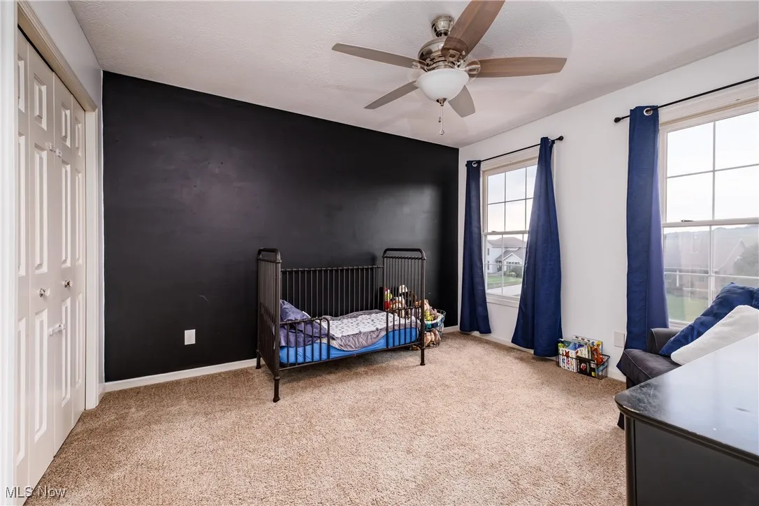 Carpeted bedroom with a closet and a ceiling fan