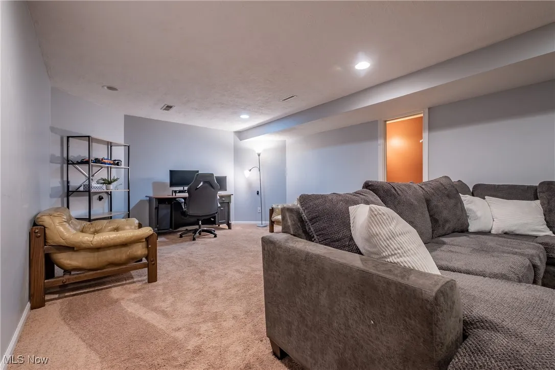 Living area featuring an office area, light carpet, and recessed lighting